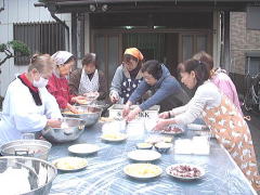 女性群は、餡と黄粉を まぶします